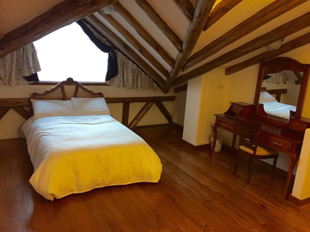 Cama bajo el techo inclinado de madera del ático Ayllu