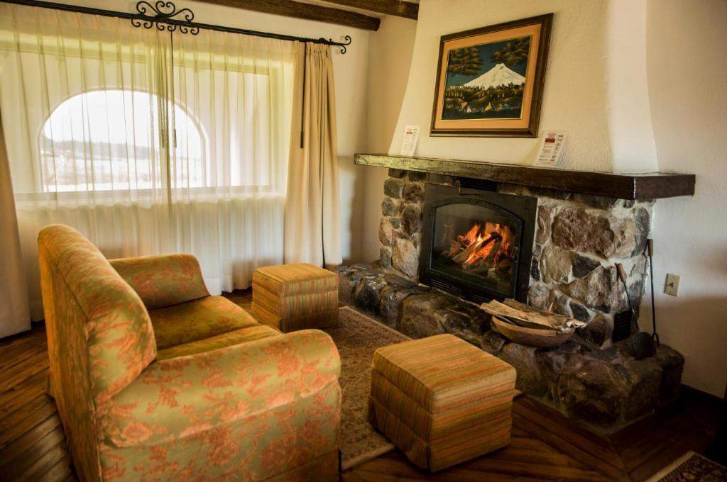 Sillón junto a la chimenea encendida en la habitación Cotopaxi