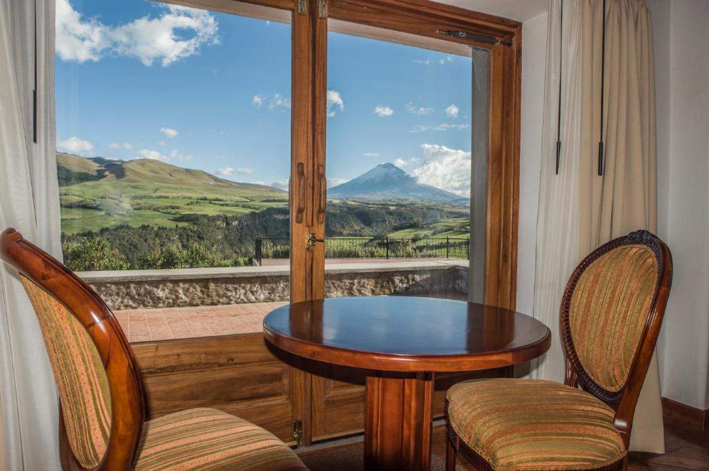 Mesa junto a la ventana con vistas al Cotopaxi en la habitación Sincholagua